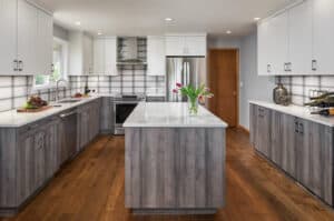 Contemporary kitchen with a center island with white countertops and white cabinets. 