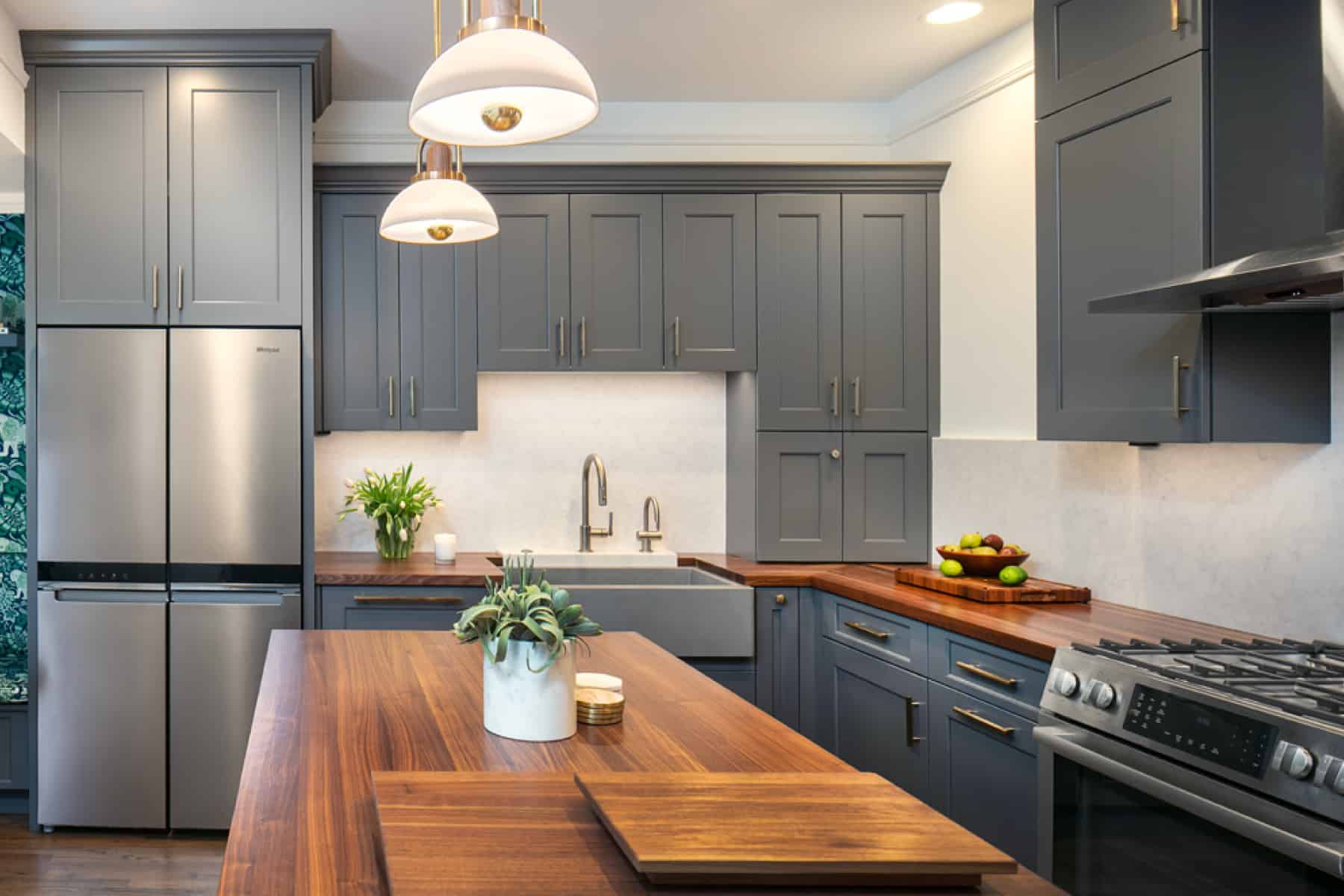 Wooden table in the middle of a renovated kitchen.