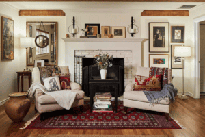 Living room with oak wood floors, two chairs, and a side-table in front of a fireplace.