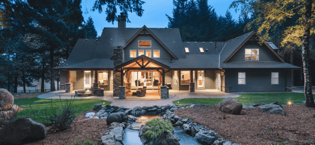 Two story Pacific Northwest home with a lit backyard patio.
