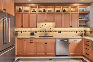 Oak kitchen cabinetry with black knobs and pull handles.