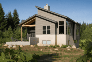 The back of a two story home with grey cedar siding. 