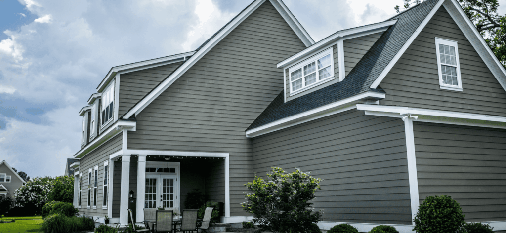 The back of a two story home with grey cedar siding.