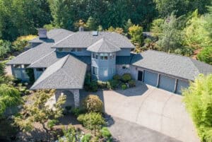 Aerial view of a large multi-story home with a sunroom, three car garage, and car port.
