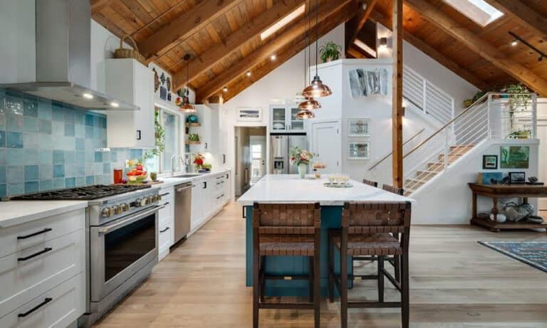Bright open kitchen with a vaulted wooden ceiling, island, and modern appliances.)
