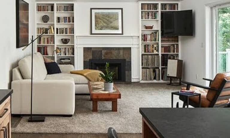 Cozy, bookshelf-lined living room with a fireplace and comfy seating.)