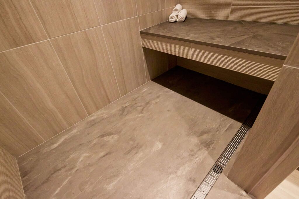 The shower floor of a remodeled mid-century inspired primary suite