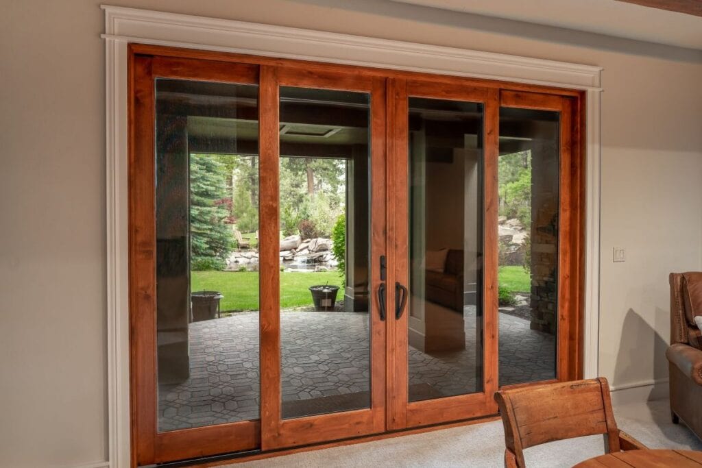 A double-wide sliding glass door with a wood frame and detailed trim millwork