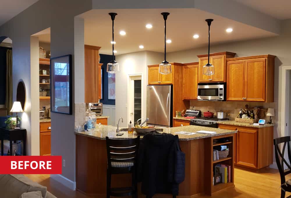 Kitchen space with a curve island, and oak-finished cabinets.