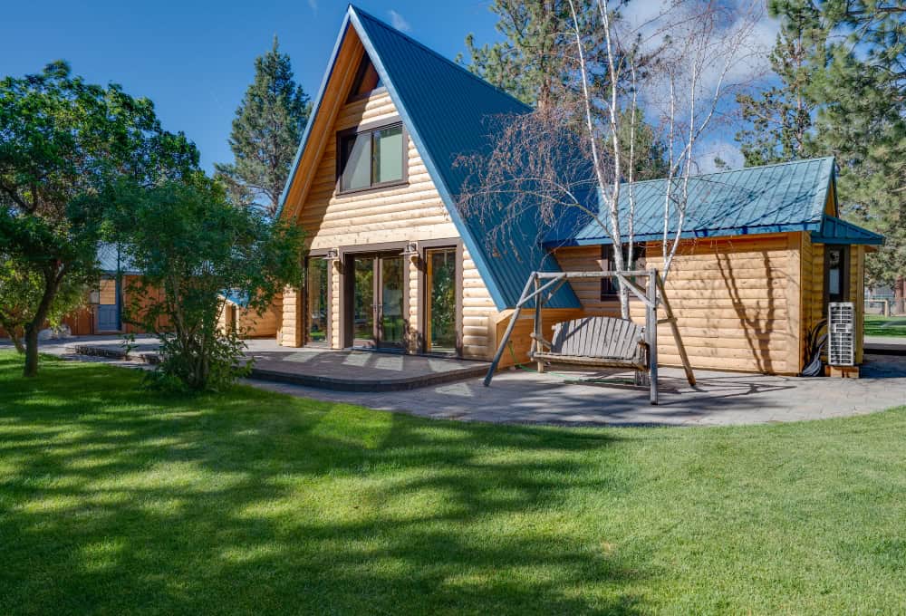 A-frame home with wood panels and a light blue roof.