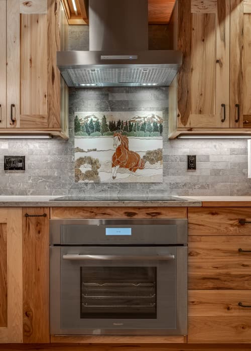 Induction stovetop with a stainless steel air vent above.