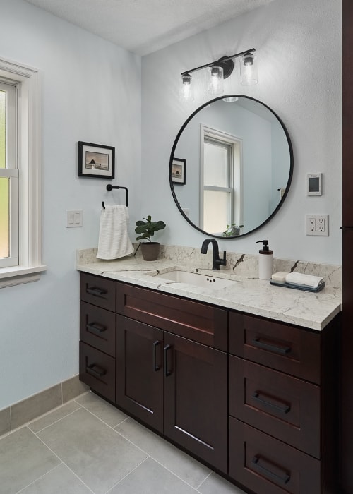 Bathroom counter from Architectural Surfaces with Moen Doux matte black bathroom sink faucet and hand towel holder.