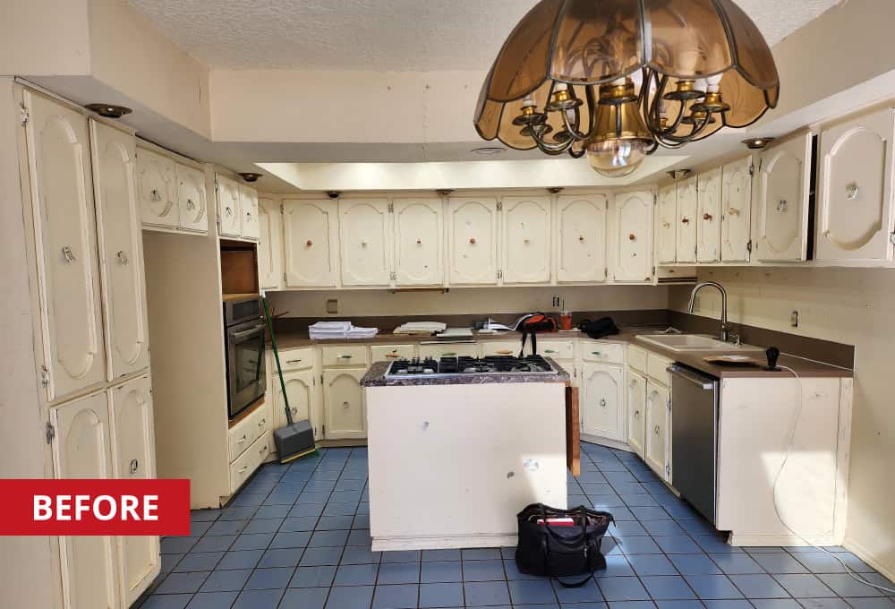 Kitchen with small island, 1970s-style light fixture, blue tile, and built-in cabinets.