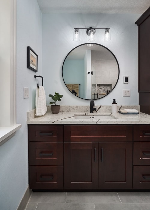 Bathroom counter from Architectural Surfaces with Moen Doux matte black bathroom sink faucet and hand towel holder.