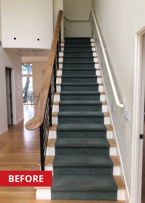 Wooden staircase with dark carpet on top.