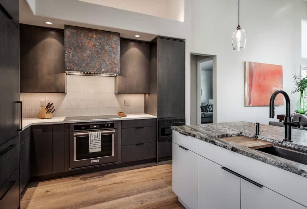 Kitchen with dark-stained cabinets, a center island with granite countertops, and black stainless appliances.