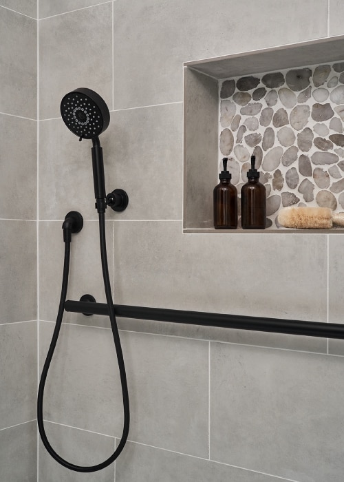 Kohler Purist matte black shower head, gooseneck, and shower bars.