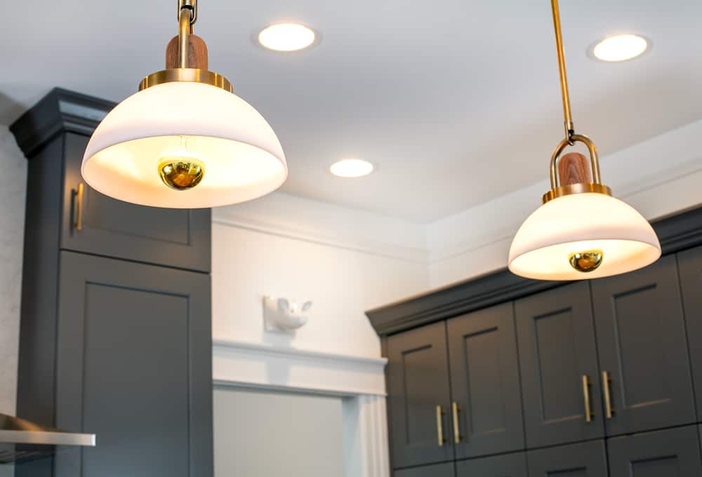 Hanging kitchen lights with white glass shades.