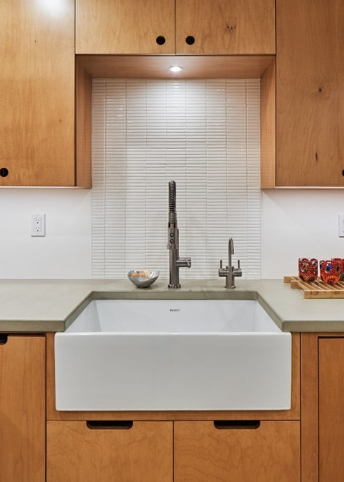 Ruvati porcelain apron sink with Pfister faucets and Pratt + Larson tile mosaic backsplash.