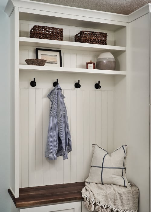 Entryway bench and storage with coat hooks and shelves.