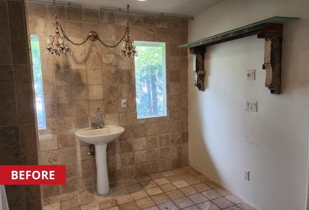 Bathroom with stone tile floors and walls with standalone sink.