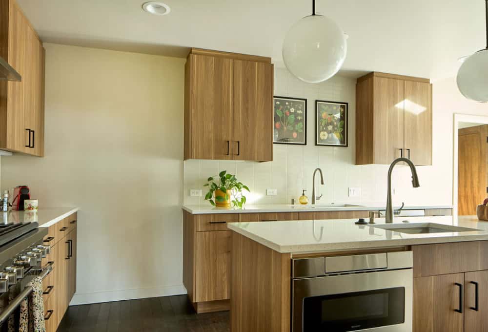 Mid-century modern kitchen with wood cabinets, large kitchen island, bright yellow chairs, and pendant lights.