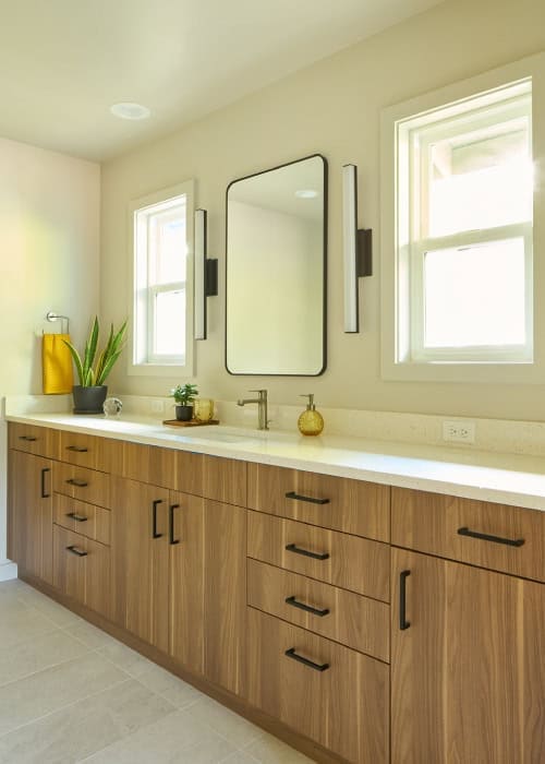 Bathroom with modern mid-century style cabinets and large square mirror.