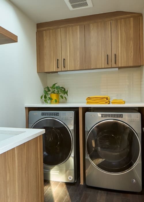 Laundry room with washer, dryer, and built-in cabinets.