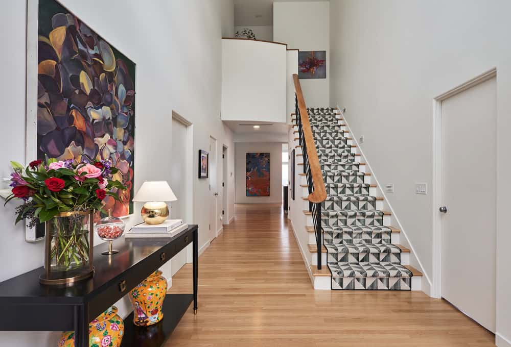 Wooden staircase with geometric-patterned Stark Carpet on the stairs.