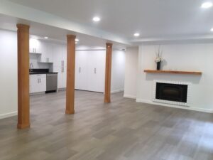 A completed basement ADU remodeling project with a firepalce and kitchen