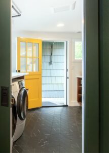 A door painted yellow leading out of a laundry room