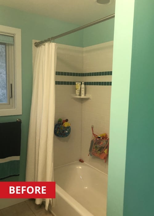 Shower/tub with white tile inside, and a white shower curtain on a metal curtain rod.