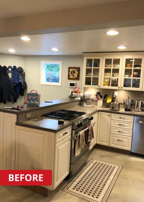 Gas stove in a kitchen with grey countertops and white cabinets.