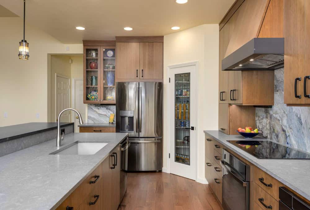 Kitchen sink across from a kitchen stovetop.