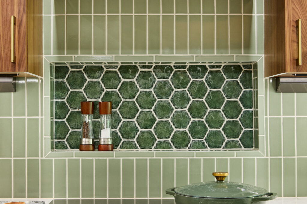 Recessed niche of green hexagonal sunburst tile, framed by the stacked green field tile.