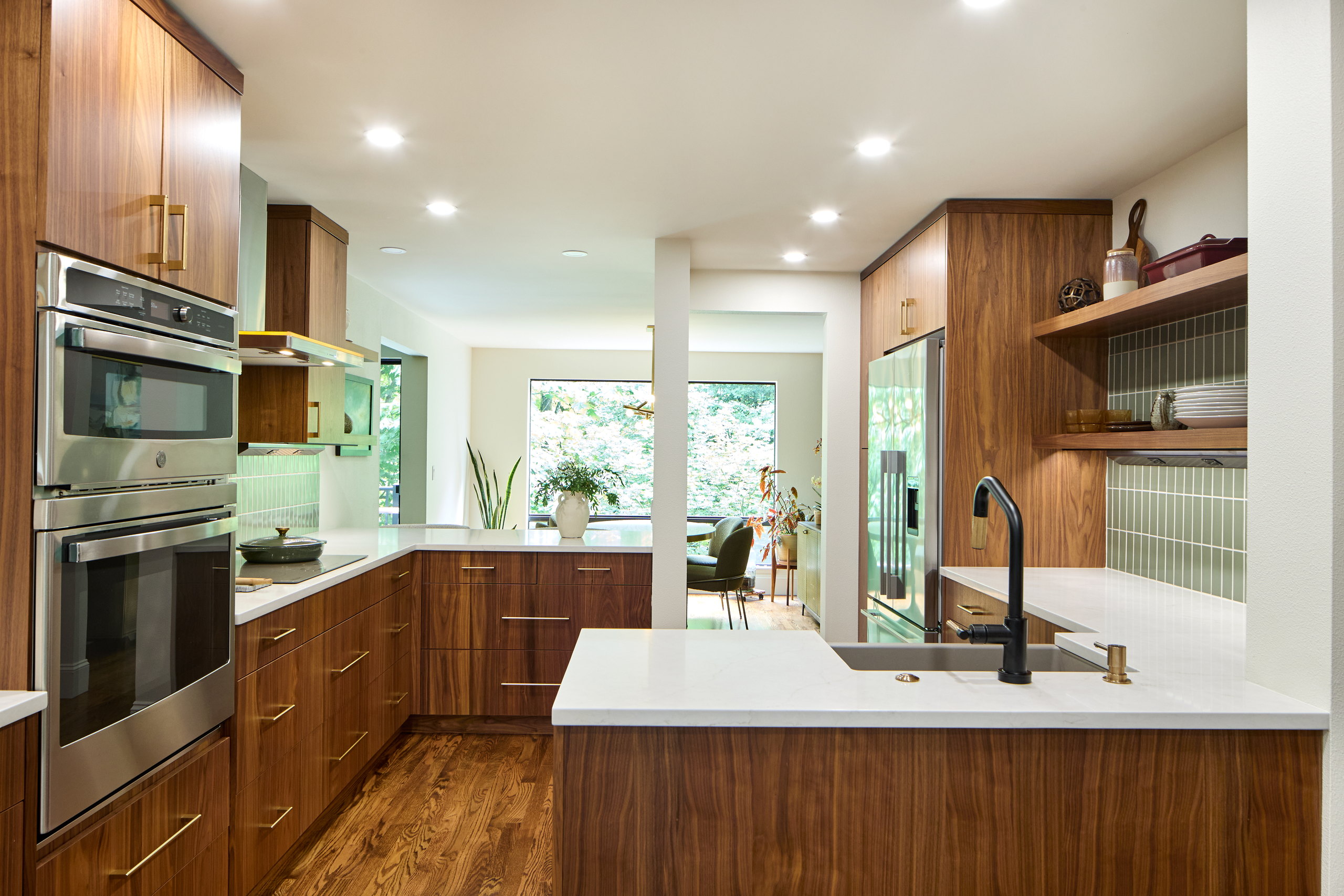 The kitchen looking toward the dining area, with the wall ovens at left and the peninsula at right.