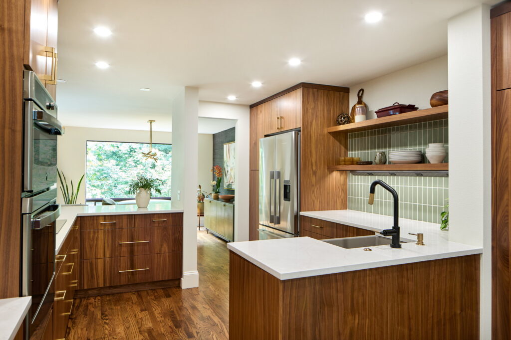 Remodeled Lake Oswego kitchen with walnut flat-panel cabinetry, white quartz counters, and a green stacked-tile backsplash.