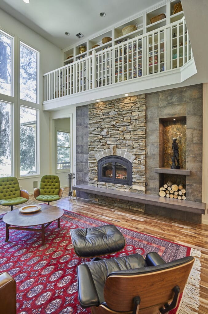The fireplace and the two-story window wall, seen from the seating area.