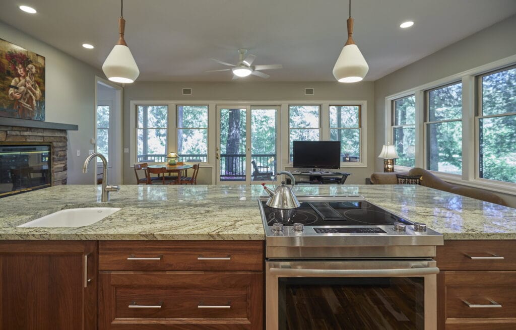 The island cooktop looking out across the living area to the windows and the deck.