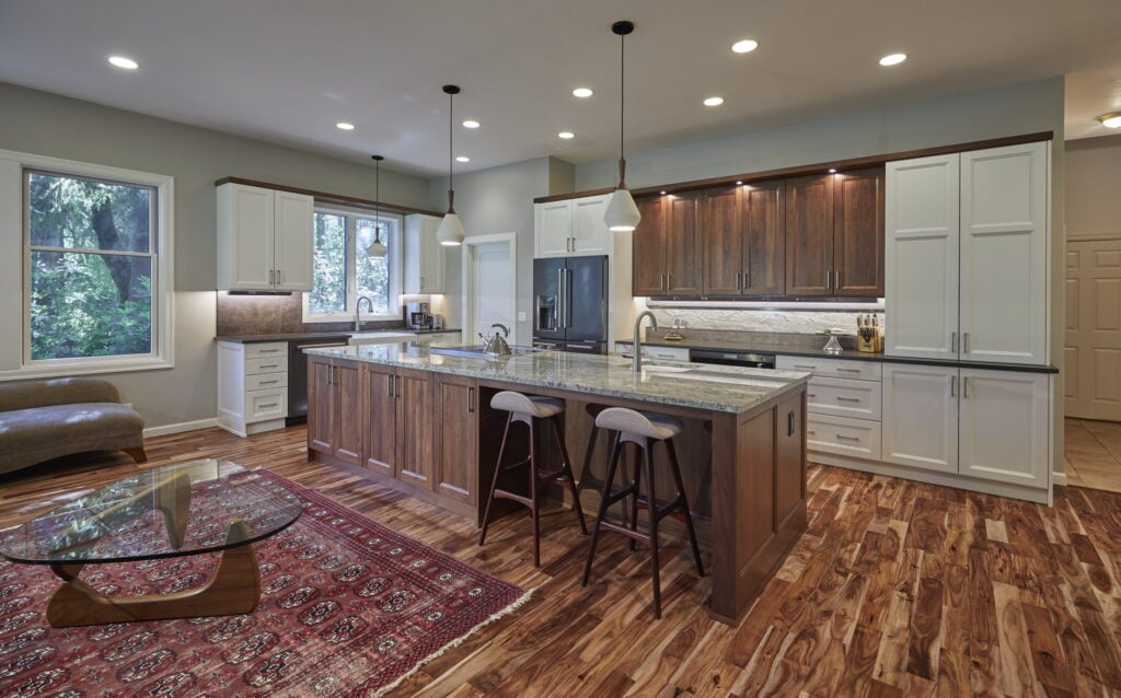 The kitchen from the living room, with pendant lights over the walnut island and acacia floors throughout.