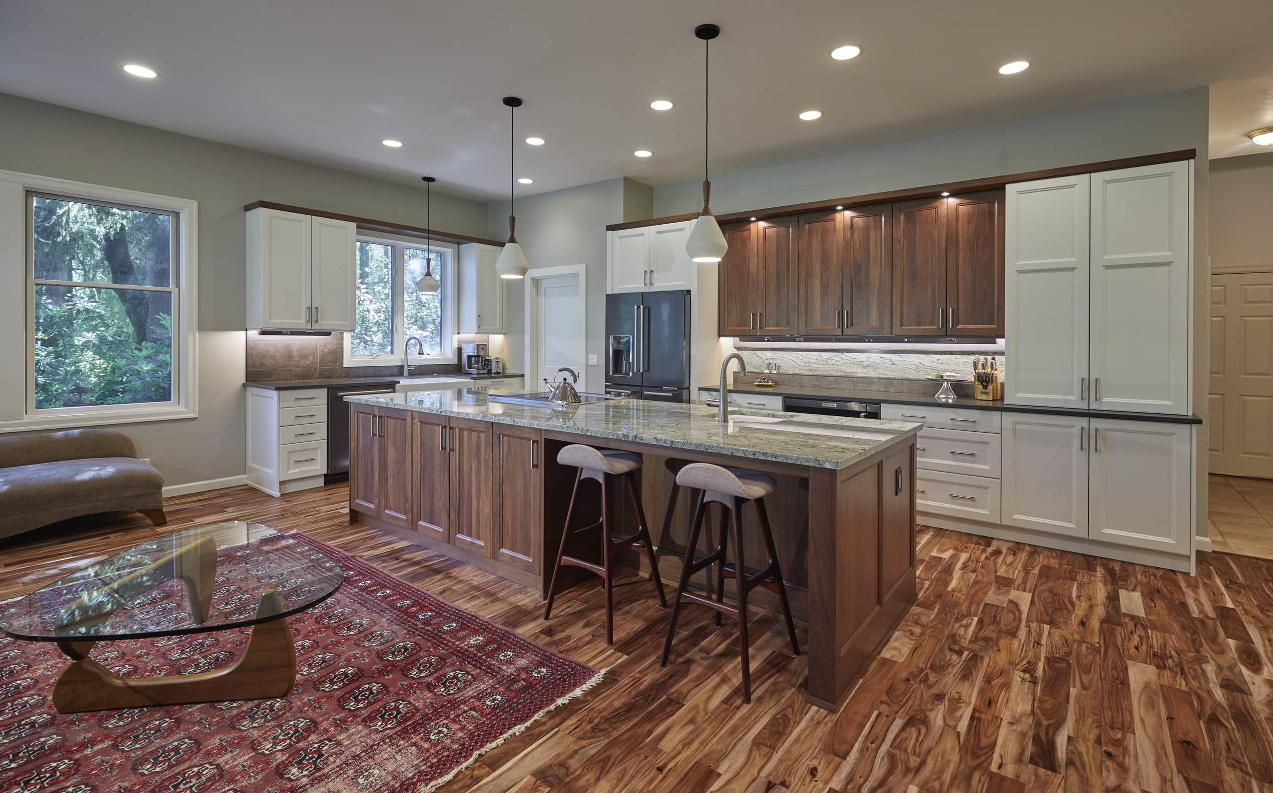 The kitchen from the living room, with pendant lights over the walnut island and acacia floors throughout.
