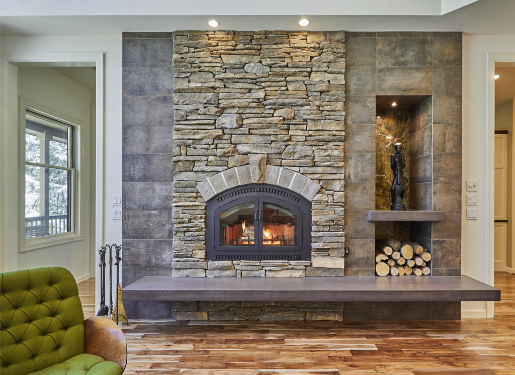 Stacked stone laid to the ceiling around the firebox, with a built-in niche for wood storage.