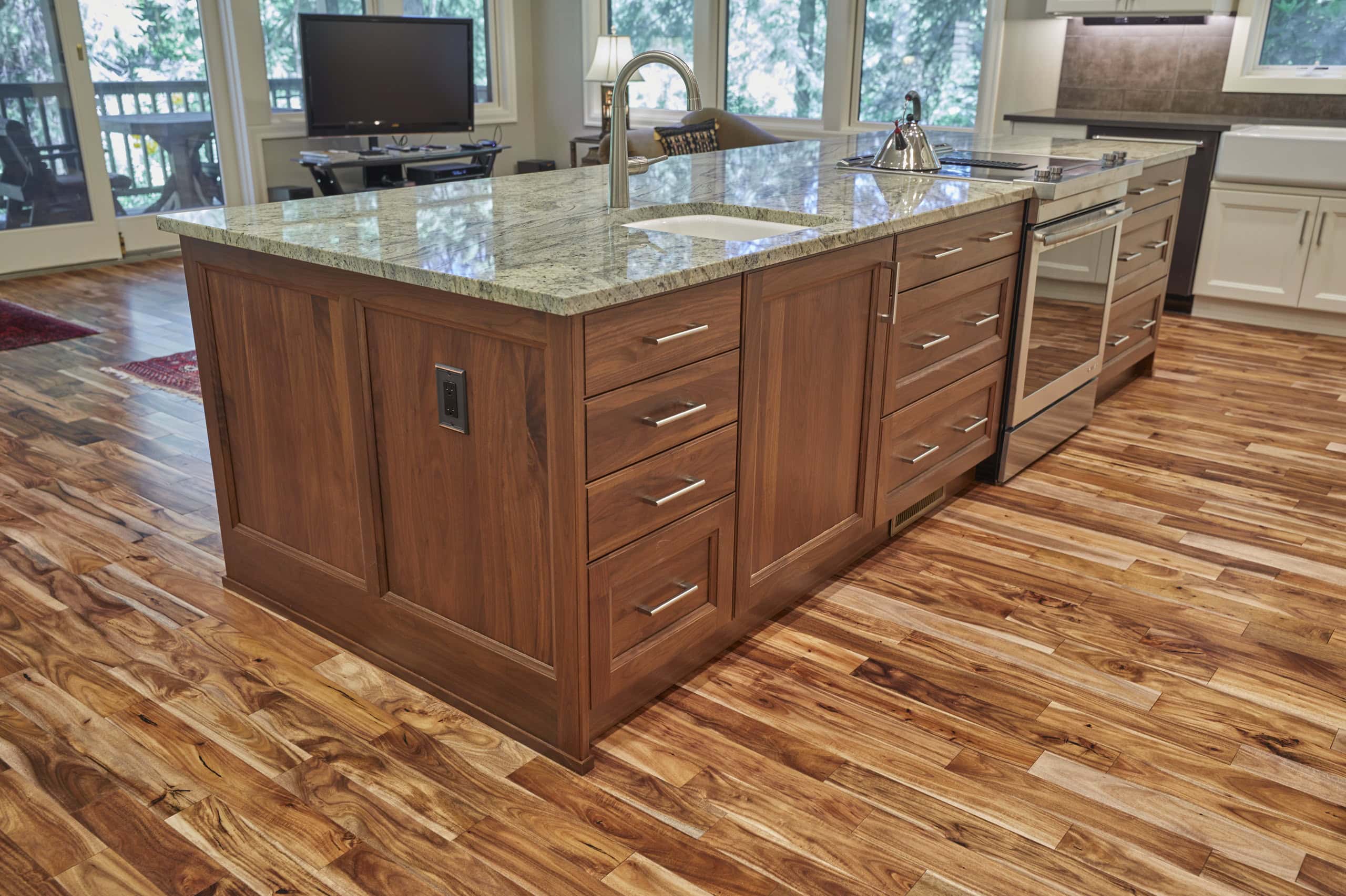 The walnut island seen from the living room, with granite counters and acacia hardwood floors.