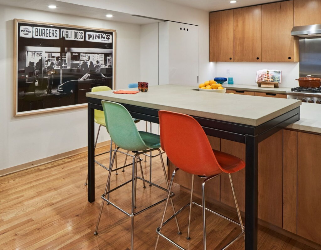The island and seating from the dining side, with a framed photograph on the wall beyond.