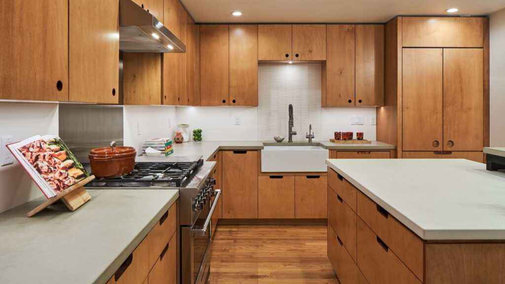Remodeled Northwest Portland townhome kitchen with natural-finish flat-panel cabinetry, concrete countertops, and a steel-framed island.