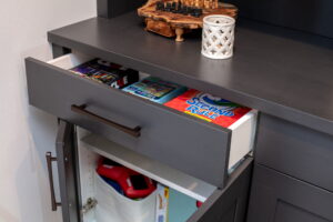 Built-in drawer opened to show board game storage.