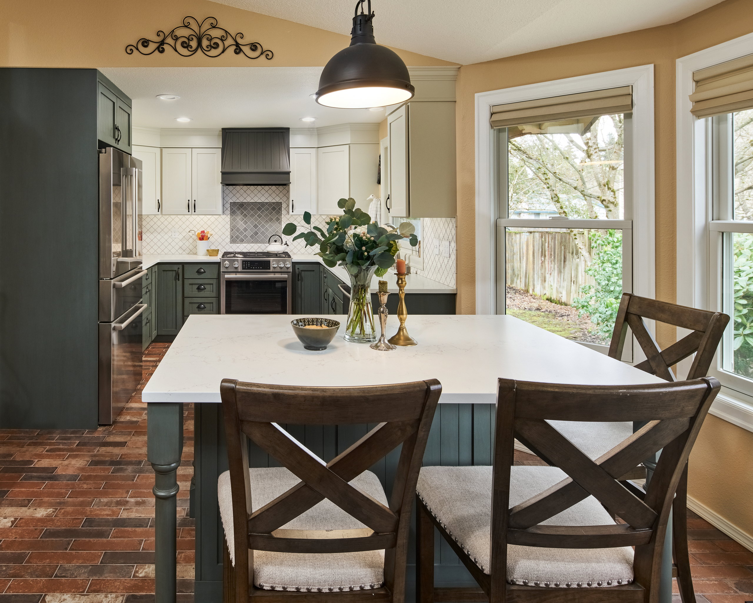 Island seating beneath a dome pendant, with the range wall and corner sink beyond.