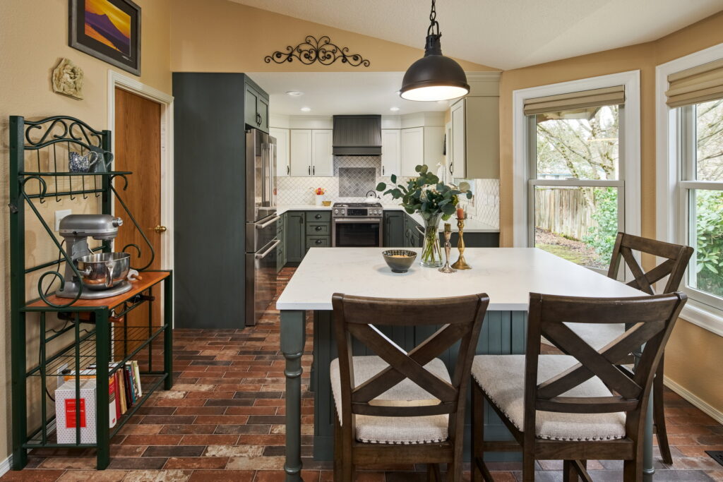 Remodeled Vancouver kitchen with a sage-green island, cream upper cabinets, and a white lantern-tile backsplash.