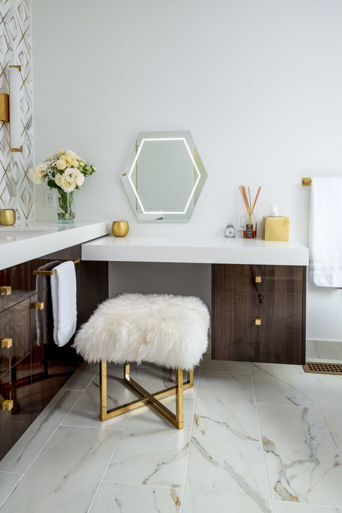 Corner makeup table with a lit hexagonal mirror and a sheepskin stool.