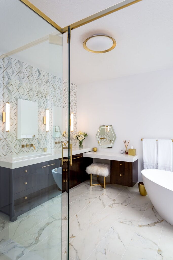 The room from inside the shower enclosure, with the vanity, makeup table, and tub beyond.